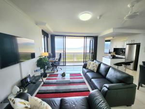 salon ze skórzaną kanapą i widokiem na ocean w obiekcie Cairns Luxury Seaview Apartment w mieście Cairns