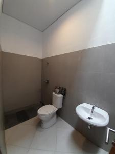 uma casa de banho com um WC e um lavatório em Bring In House Yogyakarta em Yogyakarta