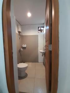 y baño con aseo y lavamanos. en Bring In House Yogyakarta en Yogyakarta