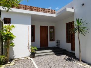 una casa blanca con una palmera delante de ella en Bring In House Yogyakarta en Yogyakarta