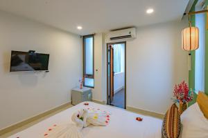 a living room with a white table and a tv at HOIANIAN CENTRAL VILLA in Hoi An