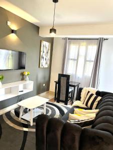- un salon avec un canapé et une table dans l'établissement Dees apartment Milimani - Fast Wifi & Secure Parking, à Kisumu
