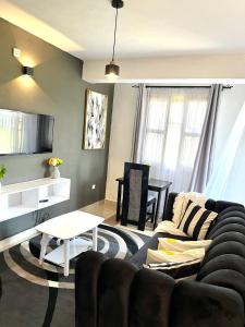 - un salon avec un canapé et une table dans l'établissement Dees apartment Milimani - Fast Wifi & Secure Parking, à Kisumu