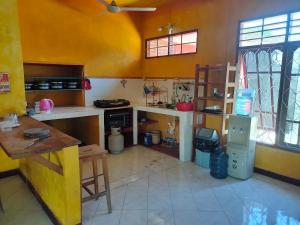 uma cozinha com paredes amarelas e um balcão em Casa Minha Backpackers Hostel em Dili