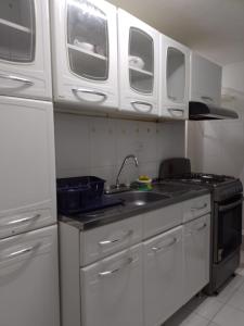 a kitchen with white cabinets and a sink at Cartagena Apartamento en Manga de 2 Habitaciones in Cartagena de Indias
