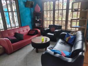 uma sala de estar com sofás, cadeiras e uma mesa em Casa Minha Backpackers Hostel em Dili