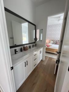 a bathroom with two sinks and a large mirror at NEW Listing in La Quinta – Stunning Vacation Home! in La Quinta