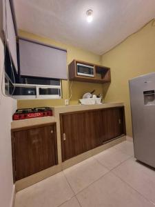 a kitchen with wooden cabinets and a microwave and a refrigerator at Departamentos fresno! Tu mejor opción in Toluca