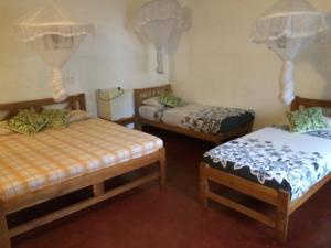 um quarto com duas camas e uma saia-cama em Hotel Mango Garden em Kandy