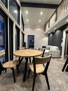 a dining room with a table and chairs and a couch at Norvamaja with a lake view, sauna and jacuzzi in Rovaniemi