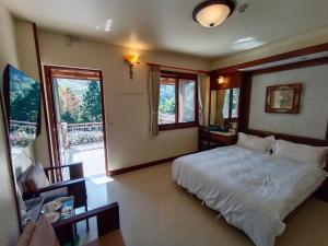 南庄的住宿－容園谷景觀渡假山莊，一间带白色床的卧室和一个阳台