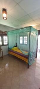 a bed with a canopy in a room at Malika Homestay in Midigama