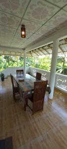 a dining table and chairs on a patio at Malika Homestay in Midigama