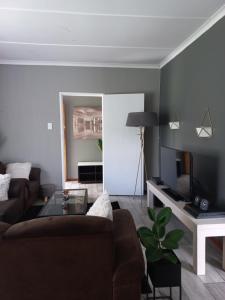 a living room with a couch and a tv at TPOKAY Self Catering Holiday Home in Pietermaritzburg