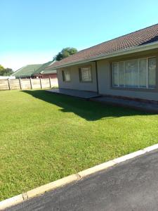 a house with a large yard of green grass at TPOKAY Self Catering Holiday Home in Pietermaritzburg