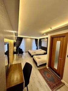 イスタンブールにあるSirkeci Quietness Hotelのベッド2台、デスク、テーブルが備わる客室です。