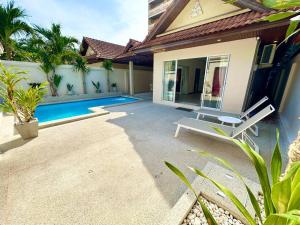 a patio with a lounge chair next to a house at View Talay Villas - Luxury, 2 Bedroom - private pool villa, 500m from Jomtien beach - VTV 86 in Jomtien Beach