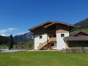 una casa con montañas en el fondo en Cozy apartment in Wald im Pinzgau with balcony and barbecue area, en Wald im Pinzgau