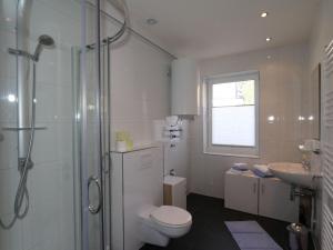 a bathroom with a shower and a toilet and a sink at Apartment in Bichlbach at the lake in Bichlbach