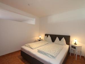 a bedroom with a large bed with two night stands at Apartment in Bichlbach at the lake in Bichlbach