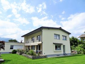 una casa blanca con un patio verde en Holiday flat, Axams en Innsbruck