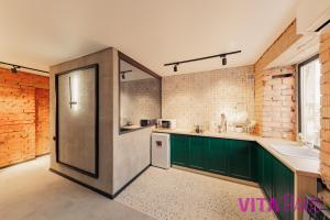 a kitchen with green cabinets and a refrigerator at Дизайнерская квартира-студия в центре Stamba in Petropavlovsk