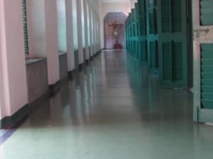 um corredor vazio de um edifício com paredes verdes e brancas em YWCA GALLWAY GUEST HOUSE em Calcutá