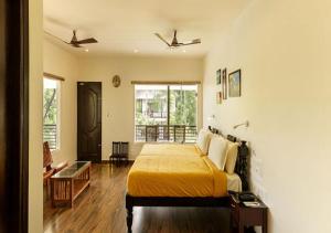 um quarto com uma cama com um cobertor amarelo em Lhasa Ayurveda and Wellness Resort - A BluSalzz Collection, Kochi, Kerala em Cochin