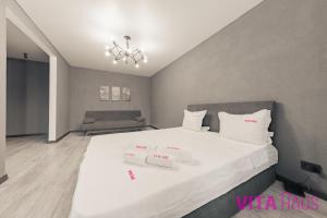 a bedroom with a large white bed with white pillows at Фирменные апартаменты в центре Дарвин in Petropavlovsk +2 photos