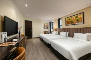 um quarto de hotel com duas camas e uma televisão de ecrã plano em San Palace Hotel & Spa em Hanói