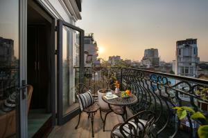 een balkon met een tafel en stoelen bij San Palace Hotel & Spa in Hanoi