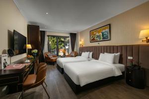 ein Hotelzimmer mit 2 Betten und einem Schreibtisch in der Unterkunft San Palace Hotel & Spa in Hanoi