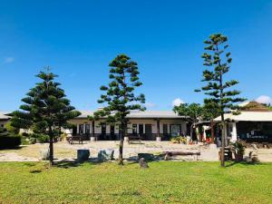 three trees in a field in front of a building at Kenting Summerland Garden Resort in Eluan