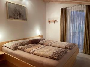 阿紹的住宿－Appartement Thurnbach，卧室内的一张大床,设有窗户