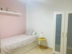 カルタヘナにあるApartamentos Duque Cartagenaの小さなベッドルーム(ベッド1台、サイドテーブル付)
