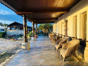 鵝鑾的住宿－墾丁盤古拉渡假花園民宿，一个带柳条椅和木屋顶的庭院