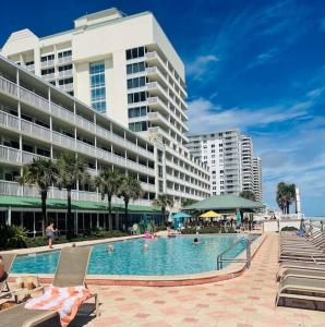 une piscine en face d'un grand bâtiment dans l'établissement Sandy Toes Beachfront Condo, à Daytona Beach