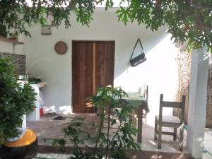 um quarto com uma mesa e cadeiras e uma porta de madeira em Moringe Home Stay - Village House em Jambiani