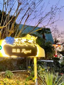 ein Schild für ein Resort mit Schreiben darauf in der Unterkunft Hanamizuki Onsen Resort in Ito