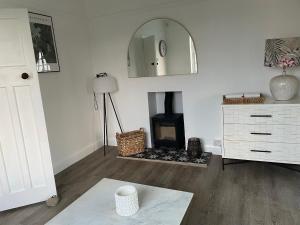 a living room with a fireplace and a mirror at Number 5, Southwold in Southwold