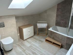 a bathroom with a tub and a toilet and a sink at Grand appartement de standing in Saint-Dizier +21 photos
