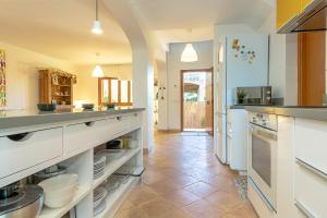 uma grande cozinha com armários brancos e piso em azulejo em Townhouse Sonrisa by Homevillas360 em Artà
