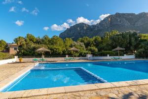 uma piscina com montanhas ao fundo em Townhouse Sonrisa by Homevillas360 em Artà