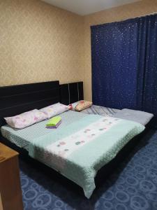 1 dormitorio con 1 cama con colcha azul en Elaine @ Home Stay, en Kota Kinabalu
