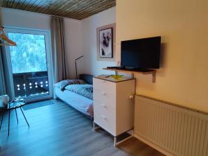 a living room with a dresser with a tv on it at Pension Almhof in Afritz