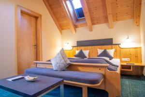 um quarto com uma cama grande e uma mesa em Hotel Garni Alpenhof em Ischgl