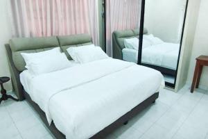a bedroom with a large white bed and a mirror at Rawang Conner lot homestay in Rawang