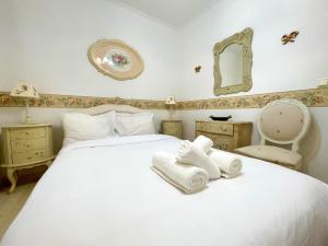 ein Schlafzimmer mit einem weißen Bett und Handtüchern darauf in der Unterkunft Flora in Nafplia in Nafplio