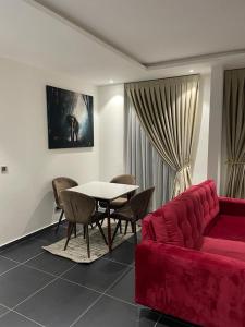 Park D-plus Apartments Cantonments في آكرا: غرفة معيشة مع أريكة حمراء وطاولة