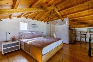 a bedroom with a bed in a room with wooden ceilings at Vivere Skopelos in Skopelos Town